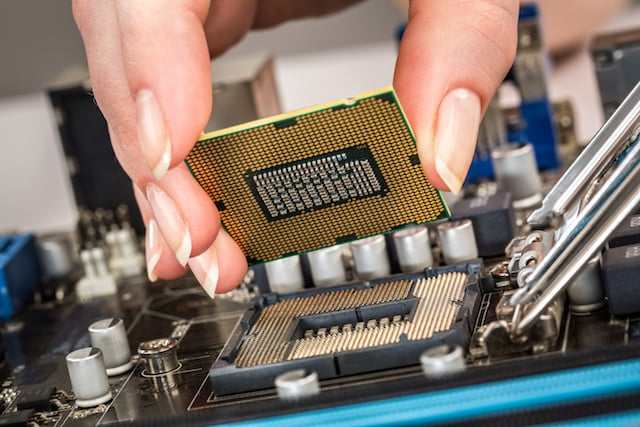 Employee placing modern processor and motherboard 